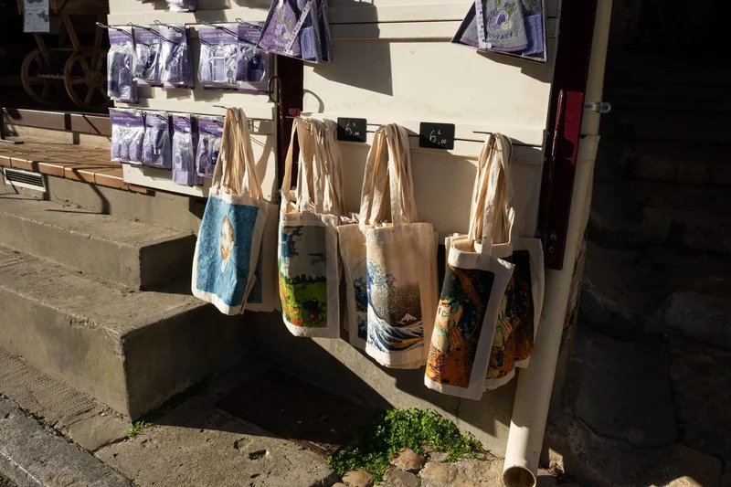 Custom-printed tote bags with varied designs displayed for sale, an example of print-on-demand products