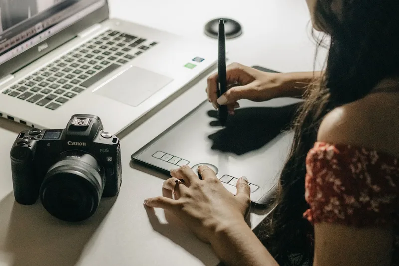 Designer using a graphics tablet and laptop to create a custom print on demand design