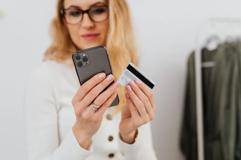 Wanita memegang smartphone untuk transaksi belanja online sebelum mendaftar sebagai seller Shopee