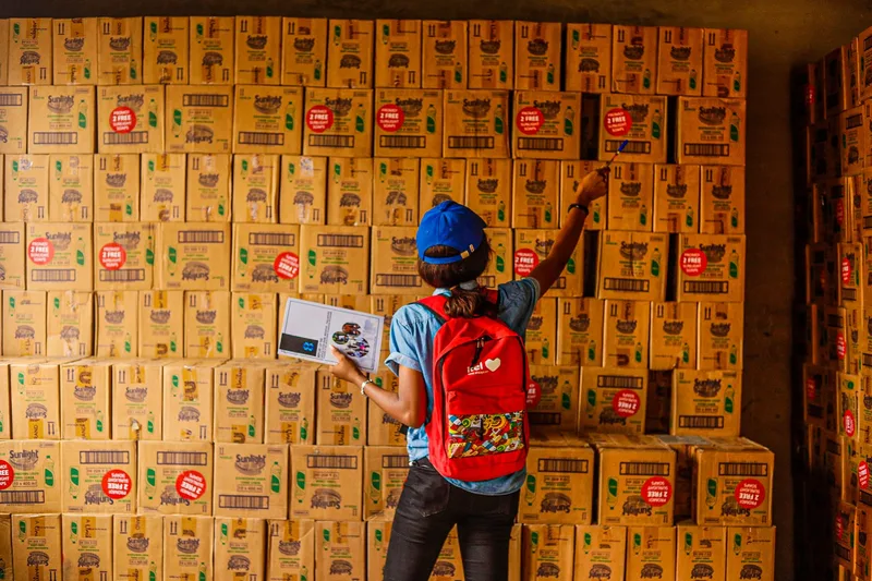 Pemilik usaha memeriksa dan mencatat stok produk di gudang sebelum memutuskan kerja sama supplier
