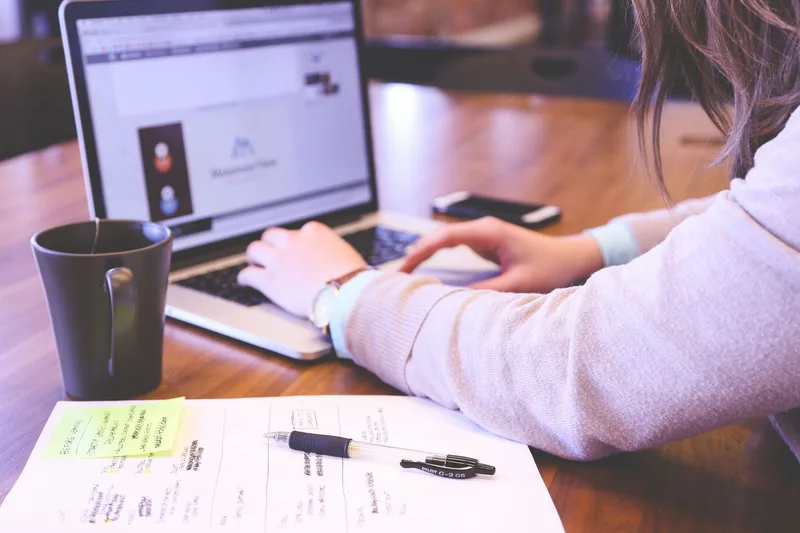 Businesswoman typing on a laptop at a desk, representing the process of setting up an online dropshipping store