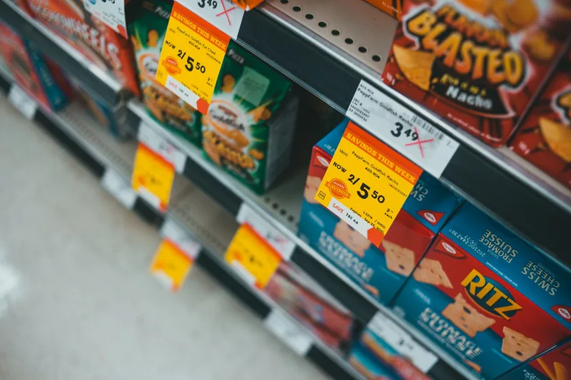 Supermarket shelves with visible price tags showing different price points and sale labels