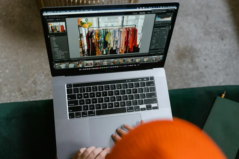 Two people looking at product listings on a laptop and phone while setting up an online store