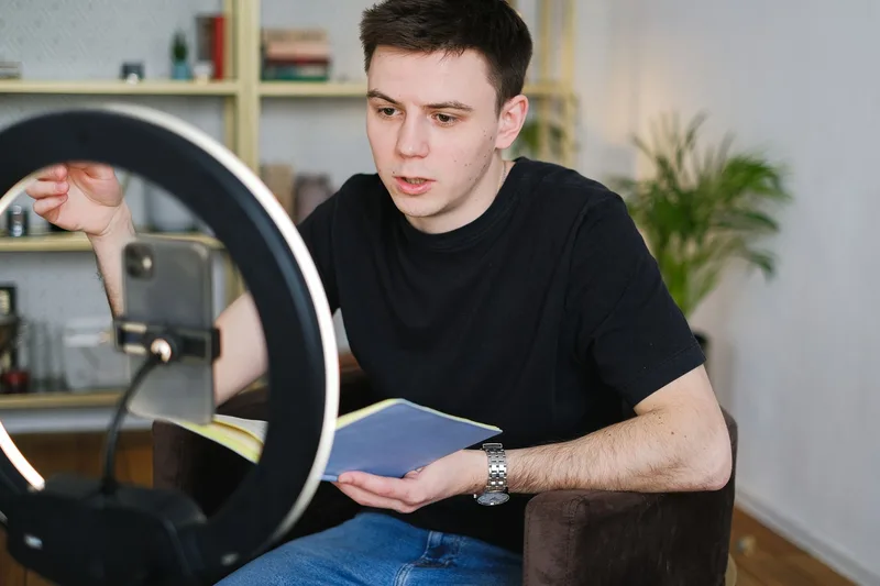 Content creator filming with a smartphone and ring light to promote products on TikTok
