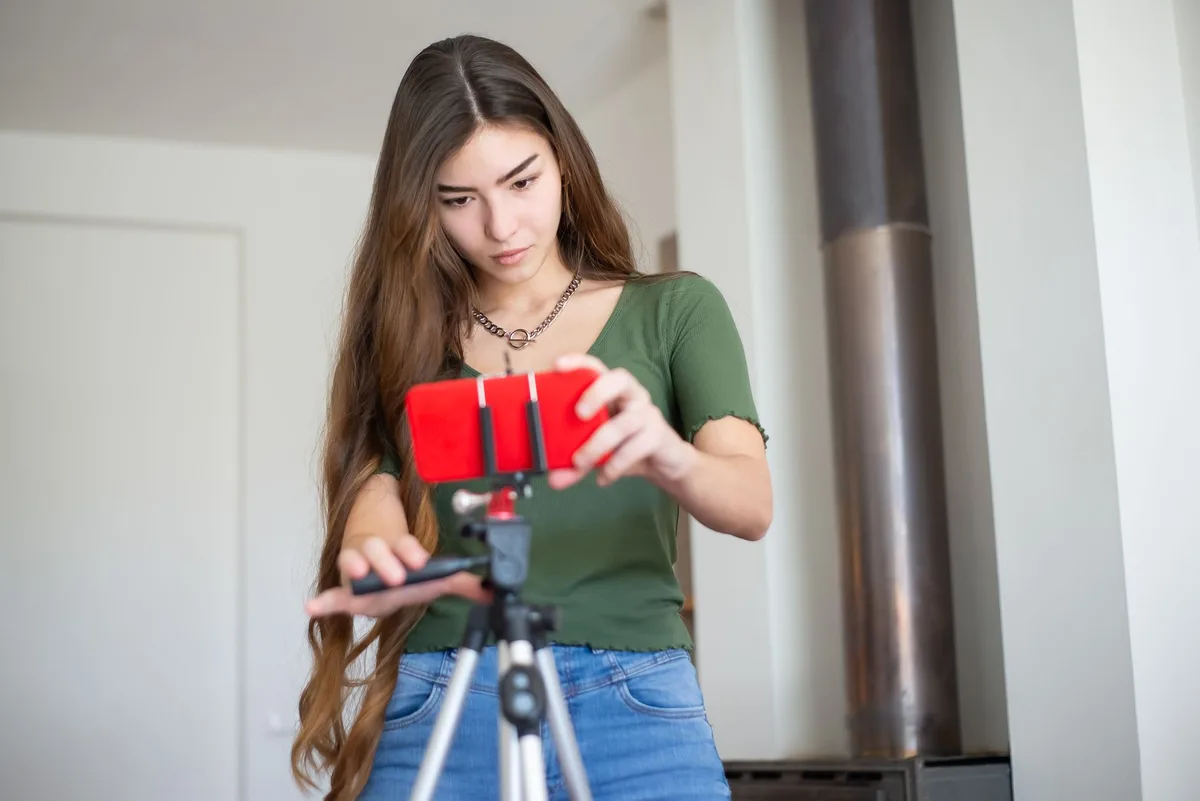 Seller adjusting a smartphone on a tripod to film a product video for TikTok Shop