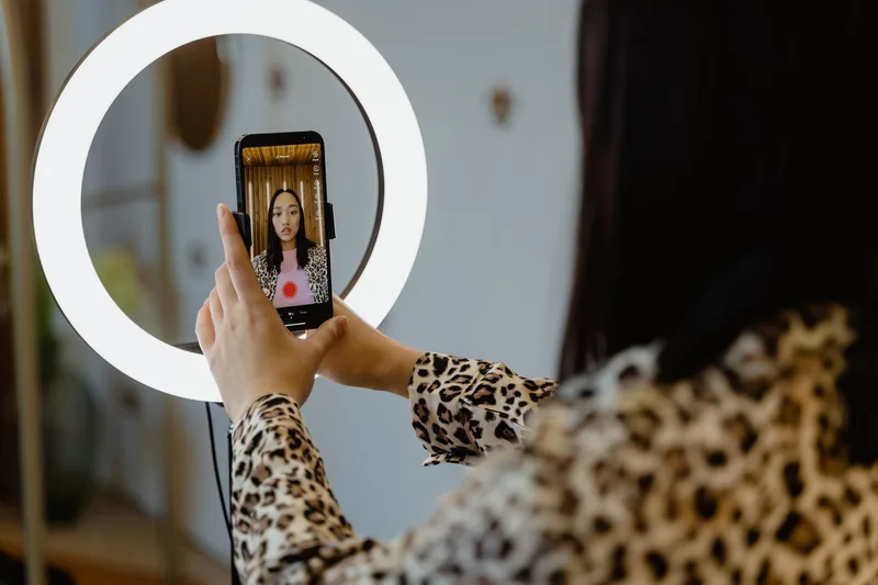 Seller using a smartphone and ring light to go live and sell products on TikTok Shop