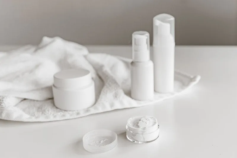 Skincare cream jars and bottles arranged on a towel for a product flatlay photograph