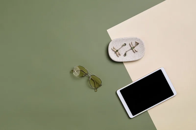 Sunglasses, earrings, and a tablet displayed on a colorful background for an online store