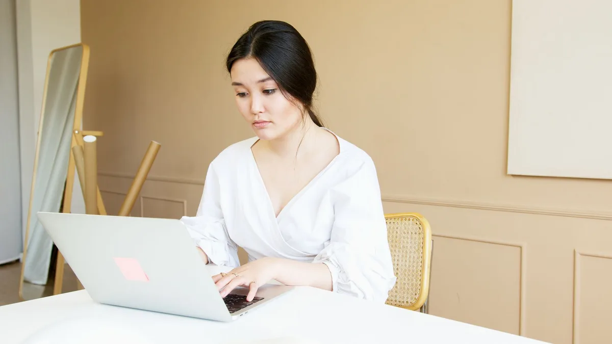 Entrepreneur researching product niche ideas on a laptop in a bright home office