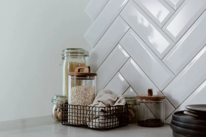 Produk organisasi dapur termasuk bekas, pembahagi laci, dan bakul simpanan disusun dalam gambar flatlay