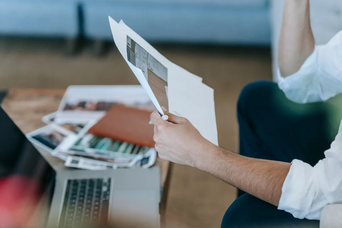Entrepreneur reviewing paperwork and a laptop while planning an online store budget