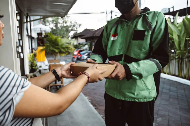 Kurir mengantarkan paket kepada pelanggan